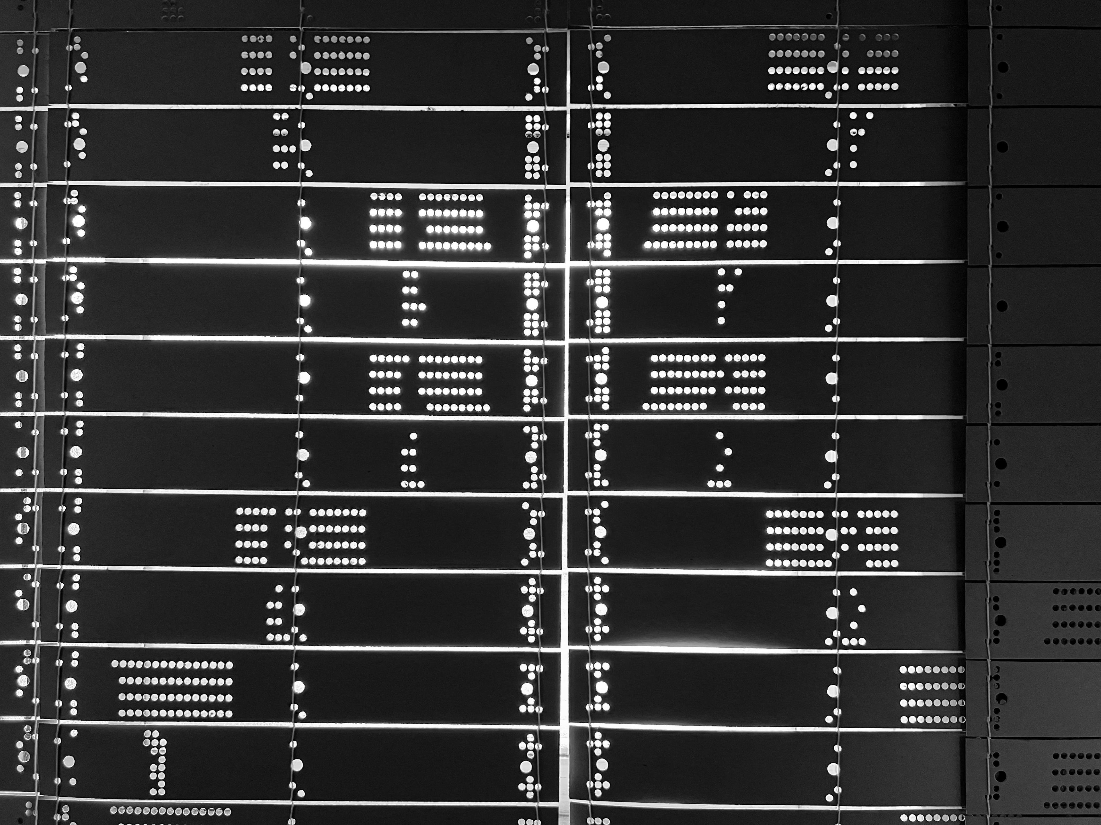 Cards in a window letting light pass through in a series of dots. They appear to be cards for a loom.