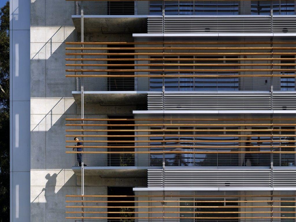 The side of a tall building with decks on each floor.