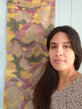 Annapurna stands next to a hand-woven tapestry featuring abstracted depictions of Princess Jasmine.