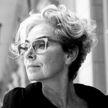 A woman with glasses in black and white.